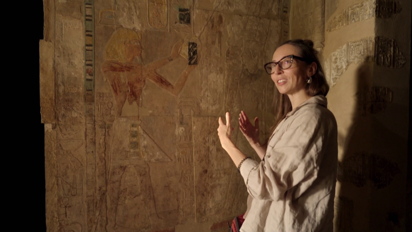 L'égyptologue Anastasiia Stupko-Lubczynska devant une représentation d'Hatchepsout sur le mur d'un sanctuaire. ("Les femmes pharaons, au pouvoir dans l’Égypte ancienne", Christiane Streckfuss, 2026)